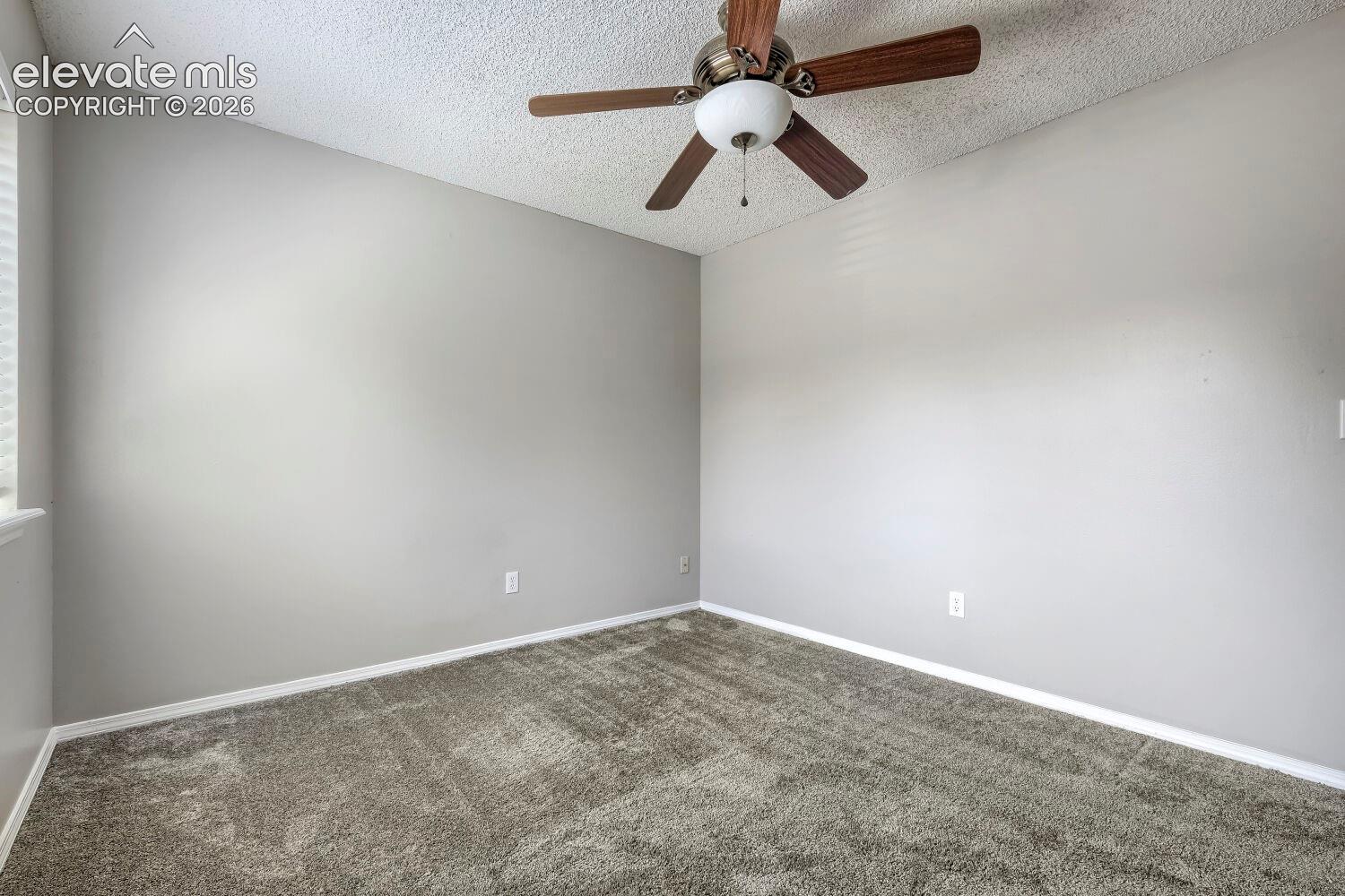 Vaulted ceiling room with ceiling fan light fixture, gray carpet flooring, and neutral wall paint