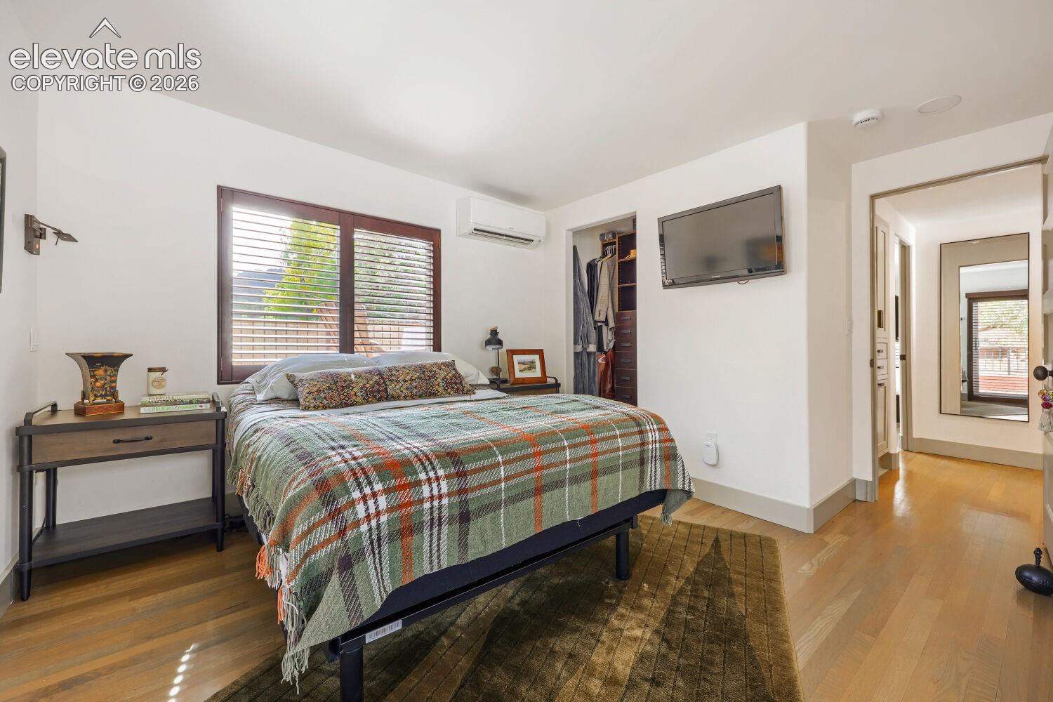 Hardwood flooring, recessed lighting, built-in closet storage, mini-split climate control system, and a wood-framed window with blinds