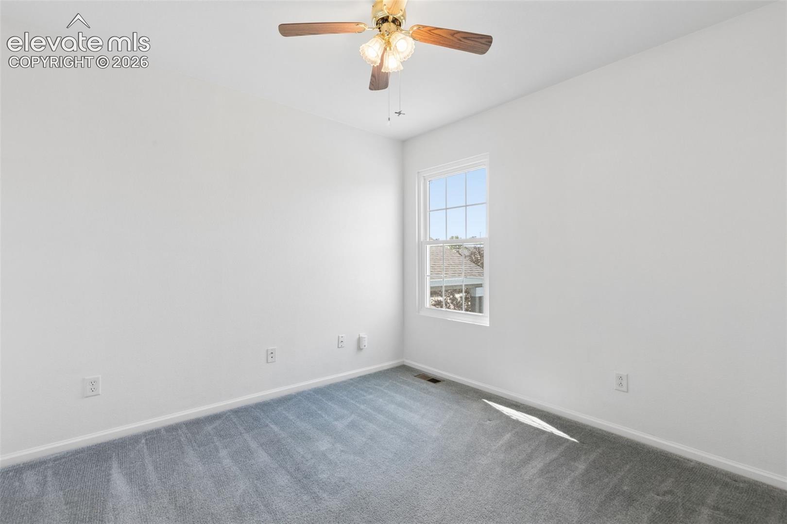 Bright room with white painted walls, gray carpet, and a ceiling fan