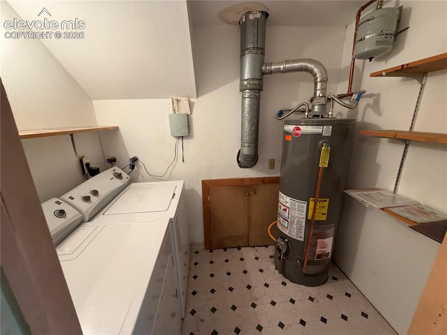 Utility area featuring an upright water heater, built-in shelving, and an access panel