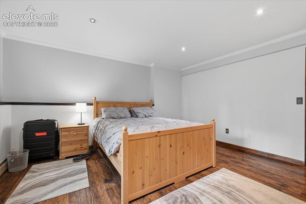 Recessed ceiling lighting, crown molding, wood-finish flooring, light gray wall paint