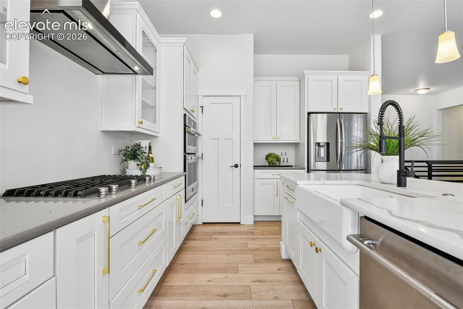 Quartz counters and farm sink, stainless appliances including gas stove