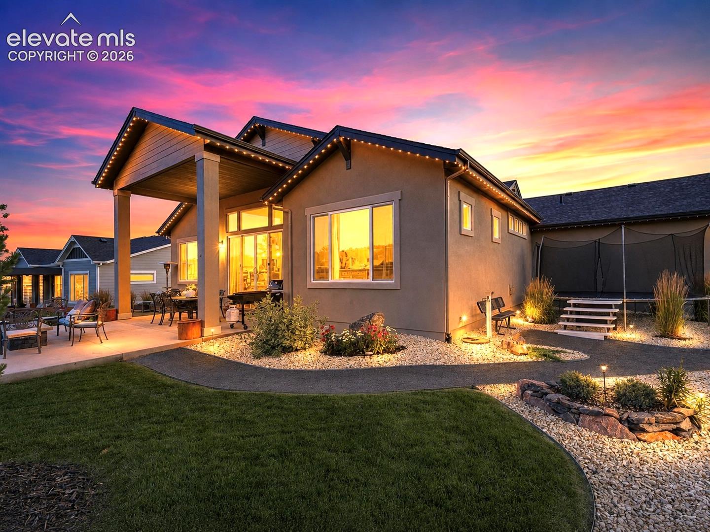 ENTERTAIN UNDER THE COLORADO SKY — Gather around the fire pit, dine al fresco on the paved patio, or simply relax while enjoying the lush, manicured backyard.