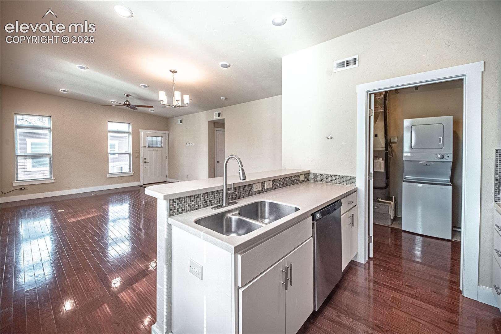 Kitchen island with a double basin stainless steel sink, pull-down faucet, and integrated dishwasher