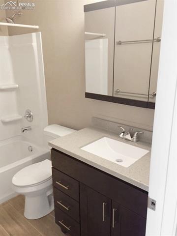 Full bath featuring vanity, shower / bathtub combination, and light wood finished floors
