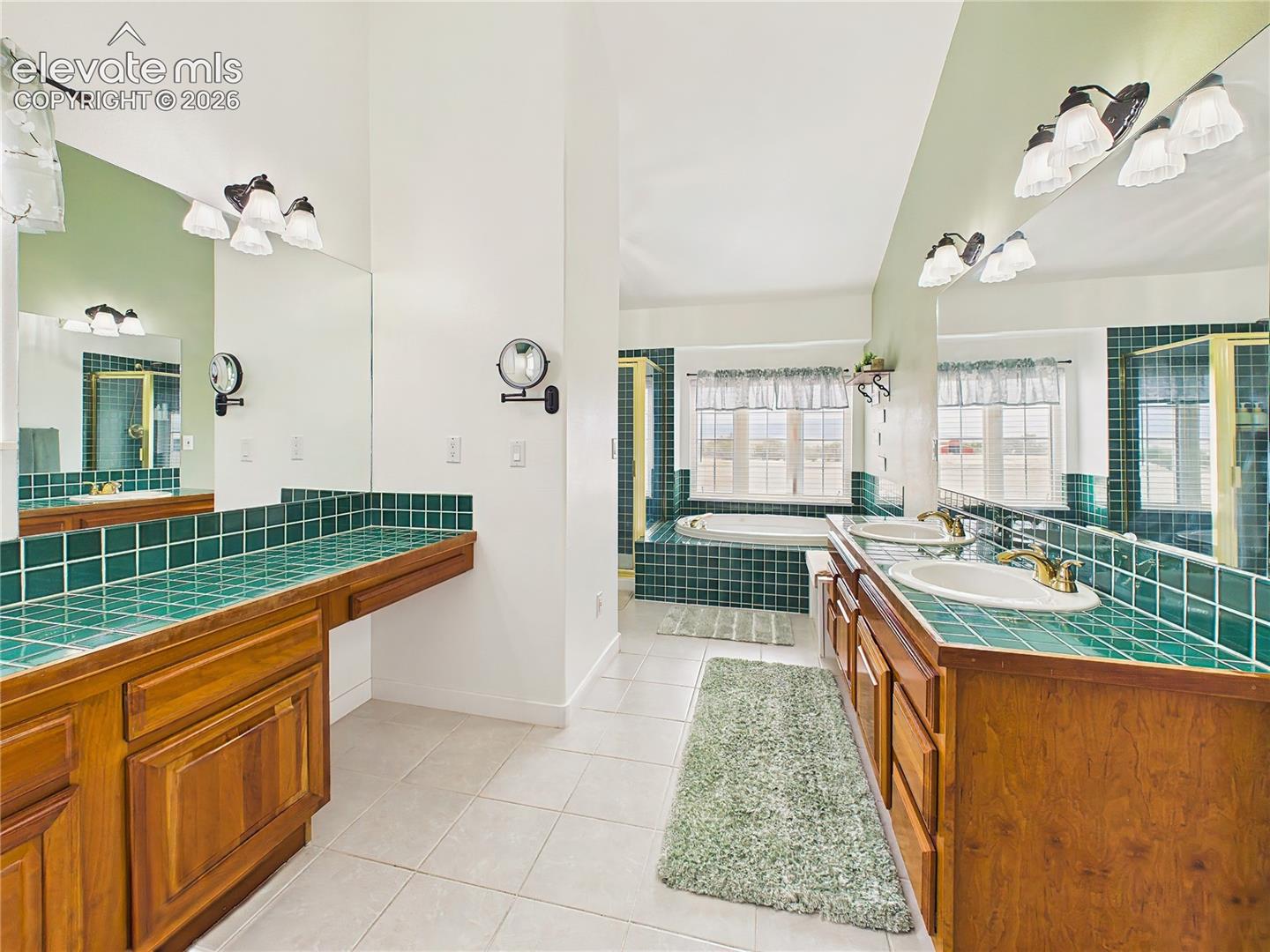 Generously sized 5-piece primary bath with dual vanities, extensive counter space, and custom tile finishes.