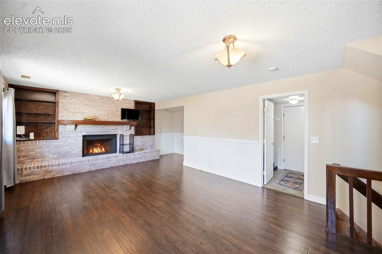 BRICK FIREPLACE WITH BUILT IN SHELVING.
