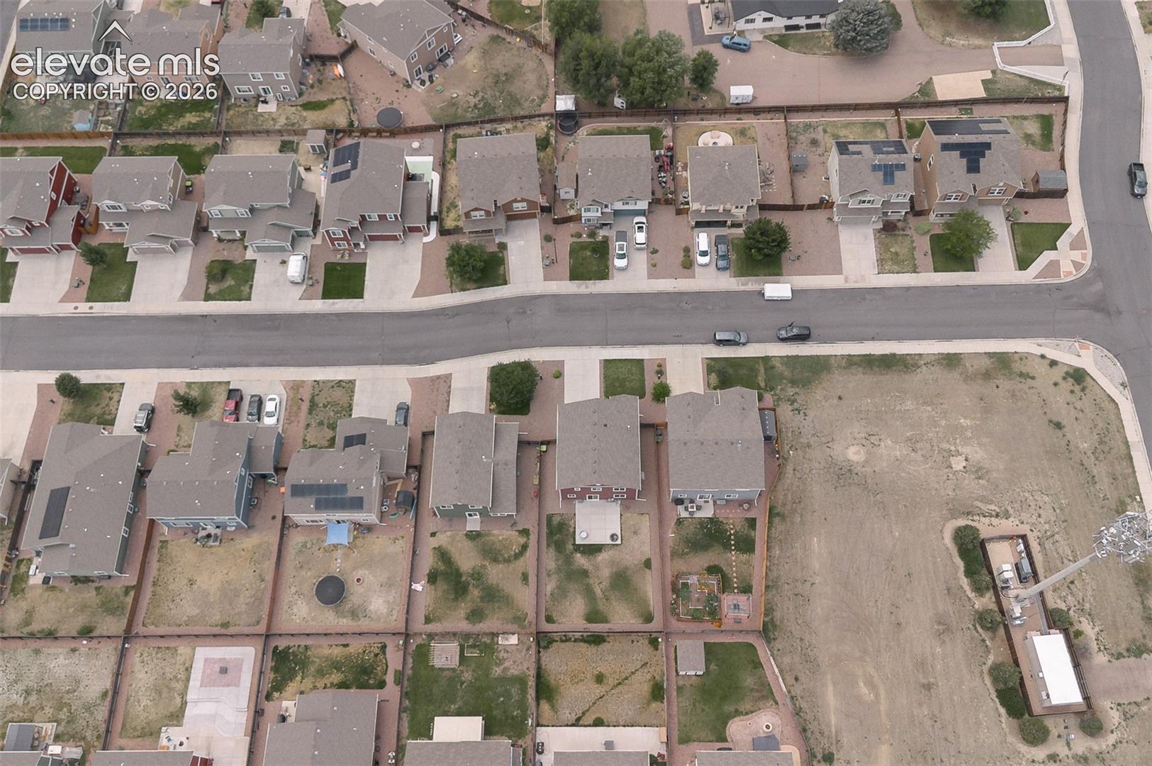 Aerial rear view home, backyard, and neighborhood.