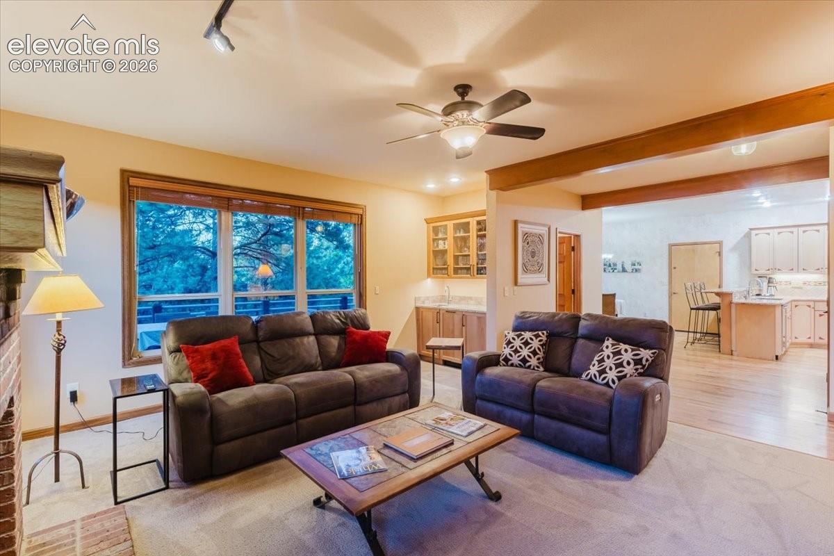 Spacious living area featuring a large window, a ceiling fan, and track lighting