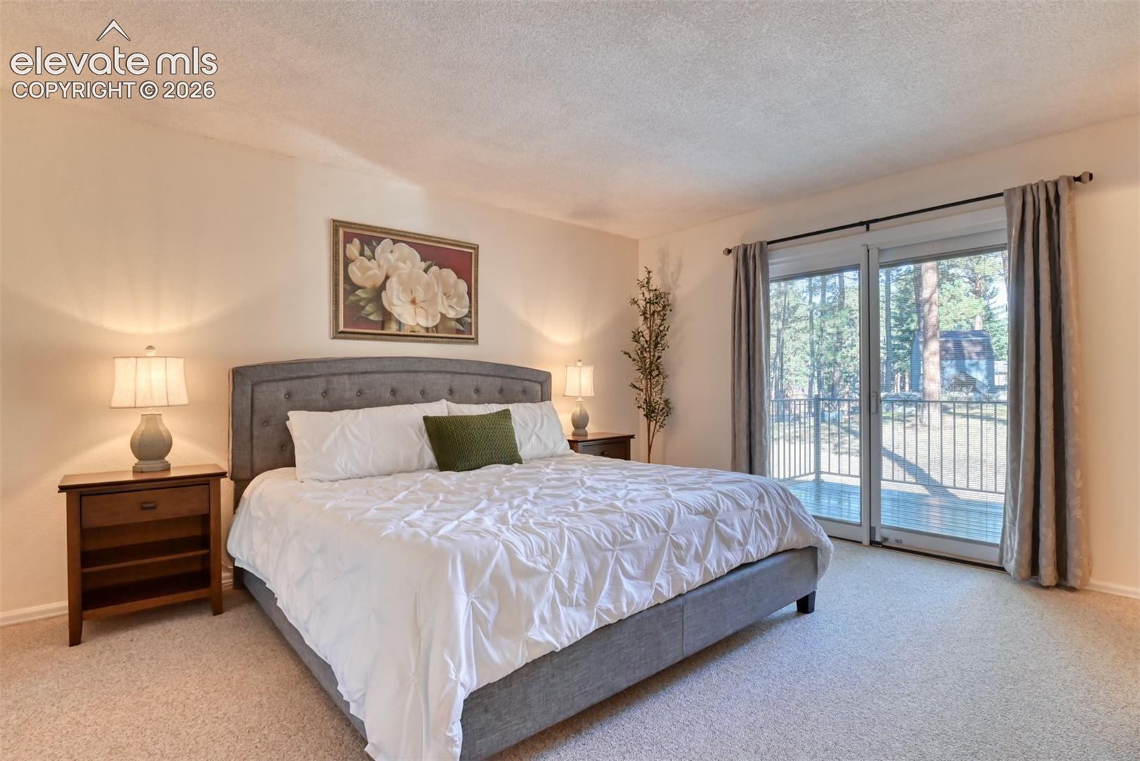 Primary bedroom with slider door providing access to spacious back deck. 