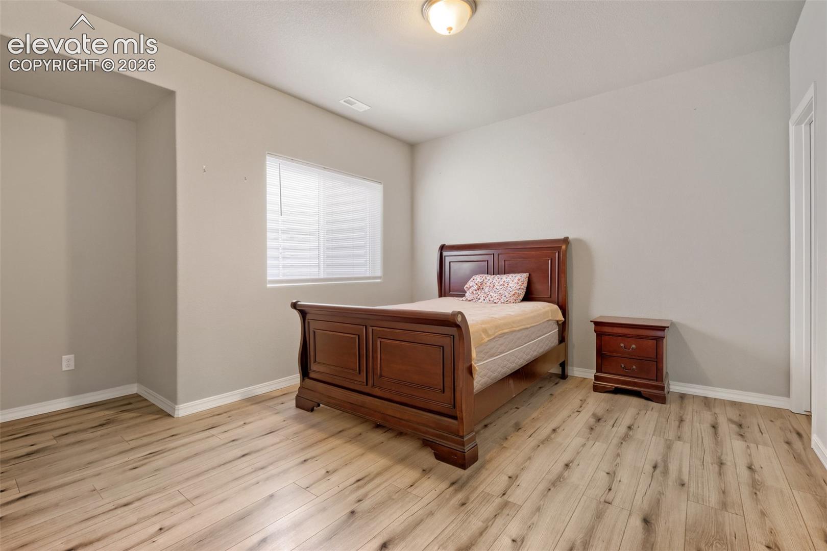 Light wood-finish flooring complements the neutral wall color