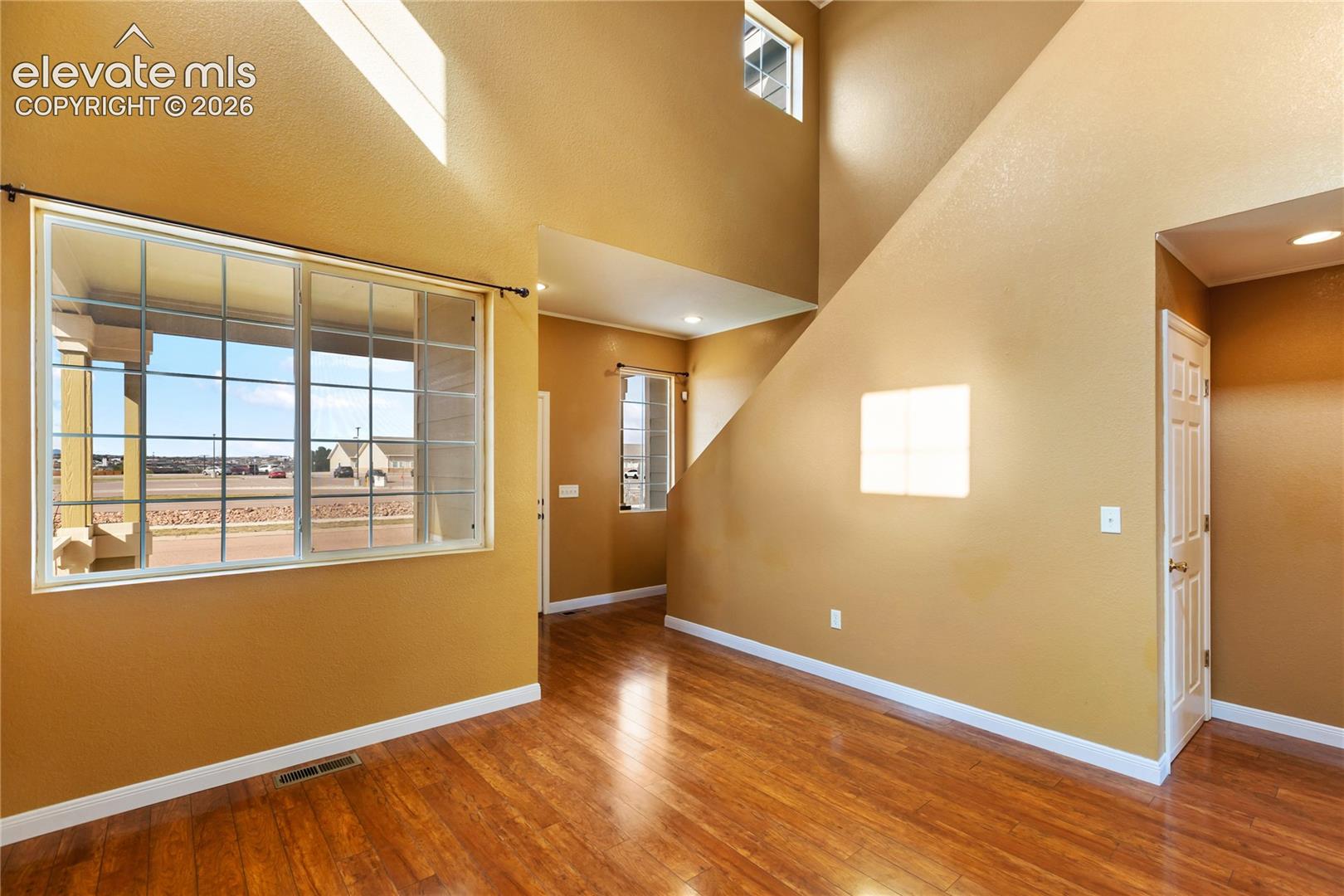 High vaulted ceilings with high windows creating a grand entrance and atmosphere. Wood lvp floors throughout add to the luxury feel.