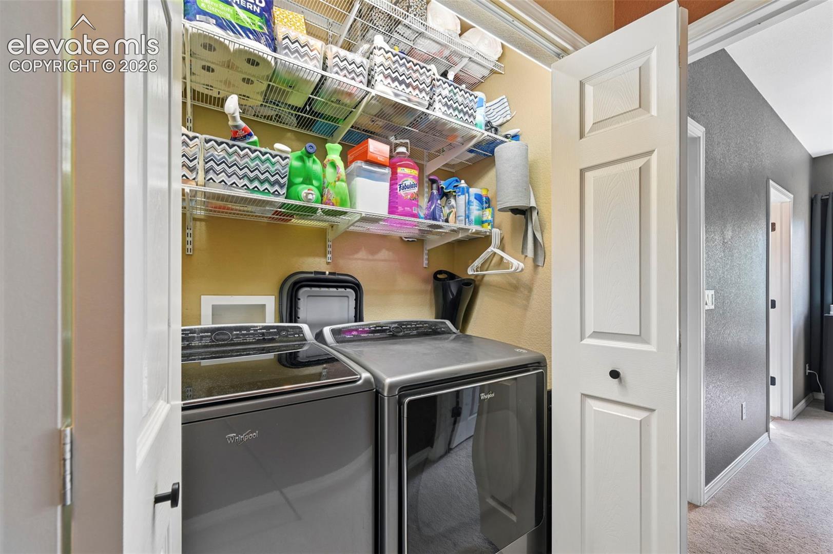 Dedicated laundry area featuring modern appliances and wire shelving