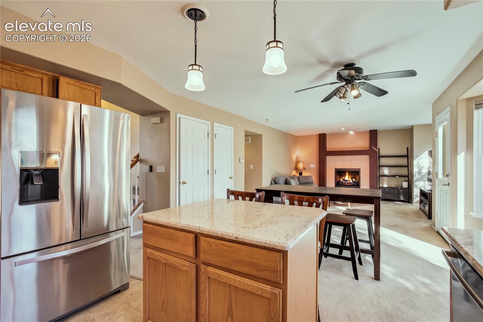 From the stainless steel appliances + center island to the nearby fireplace and dining area, this layout combines practical workspace with inviting places to gather.