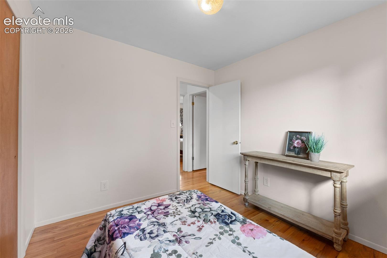 Hardwood flooring throughout, white interior walls, and an overhead light fixture