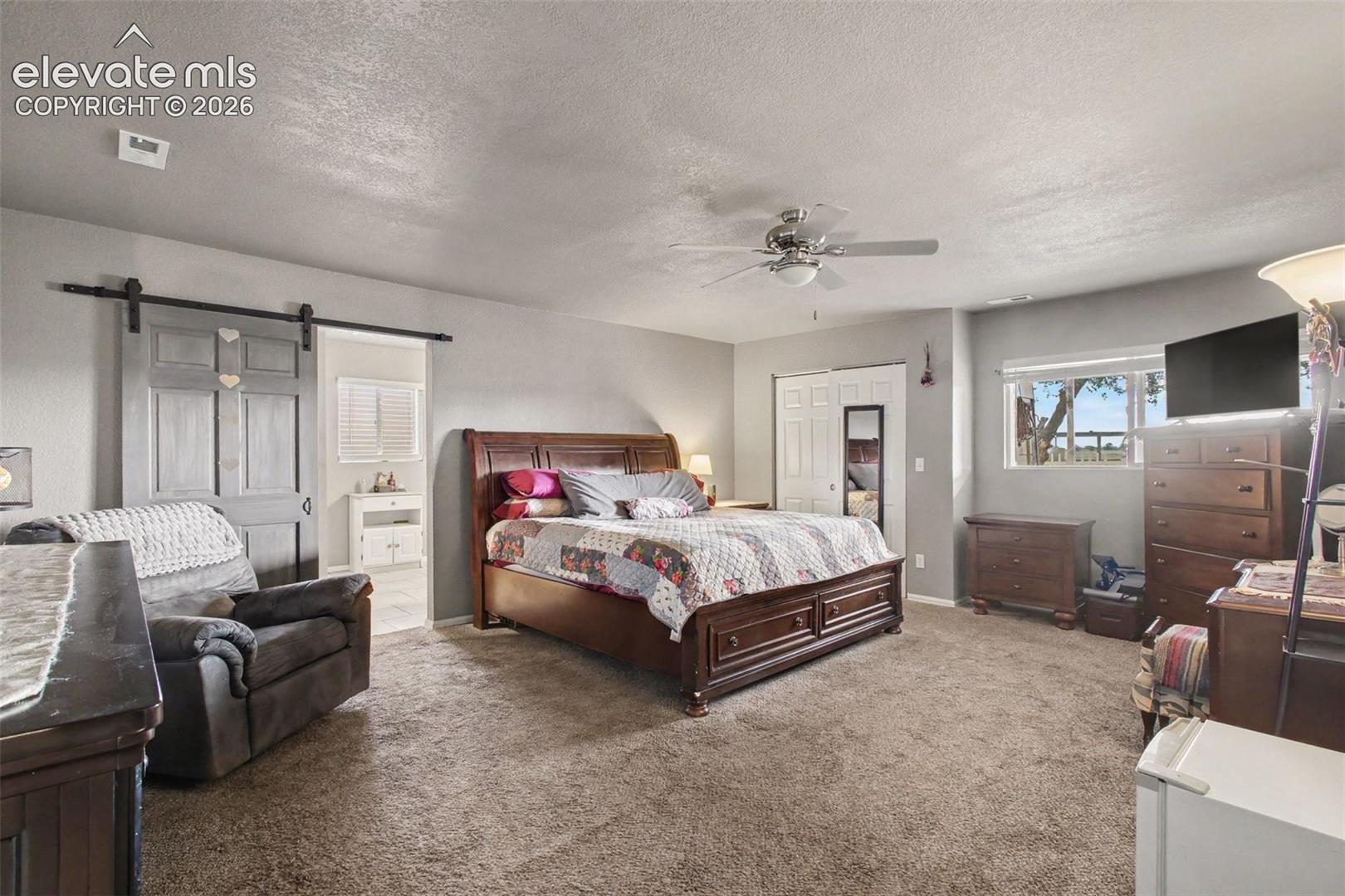 Inviting primary bedroom featuring a stylish barn door and direct access to the luxurious 5-piece primary bathroom, creating a private and relaxing retreat.