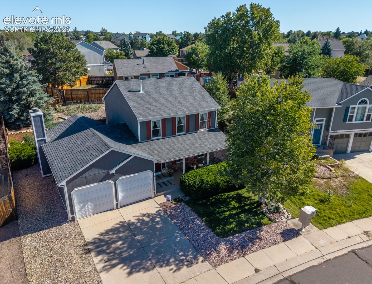 Two-story residence with a covered front porch, attached two-car garage, and a concrete driveway