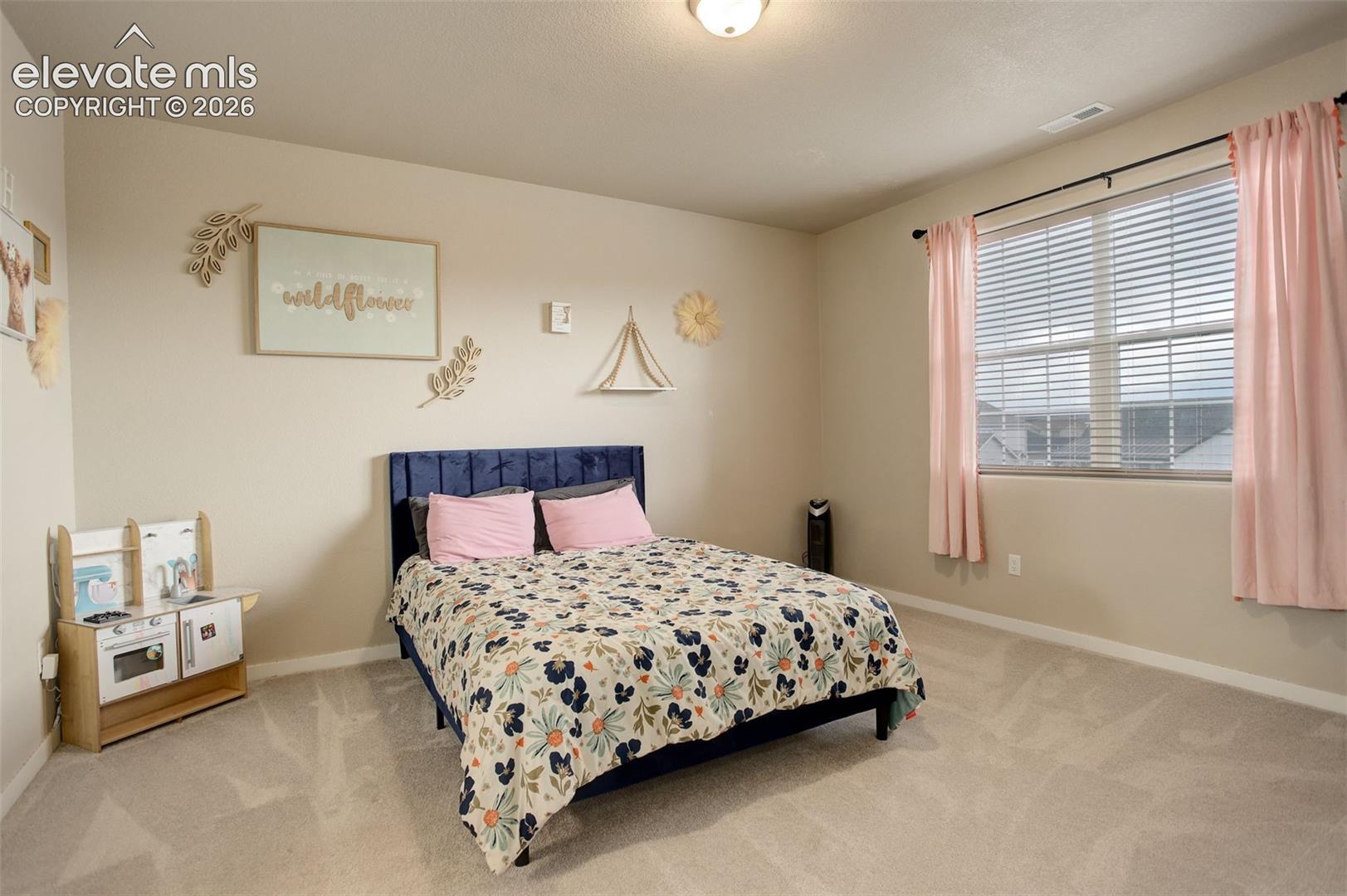 Bedroom with light carpet and ensuite bath