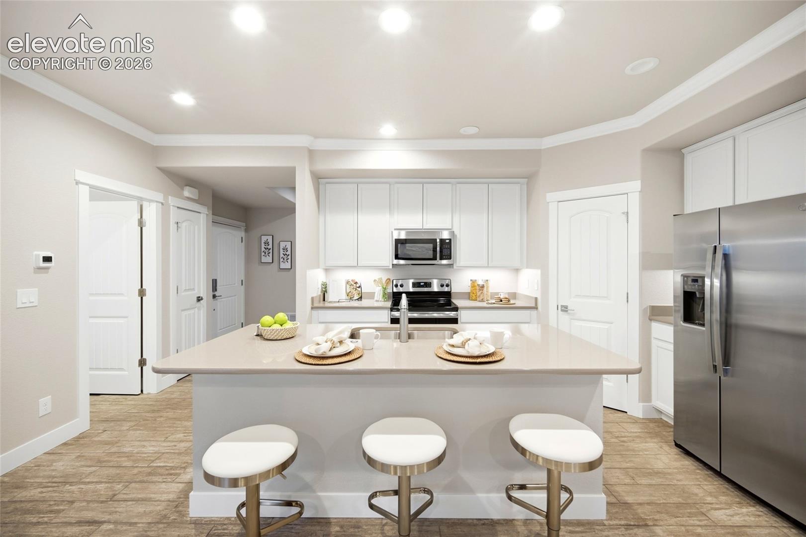 Kitchen with quartz island and white shaker cabinets