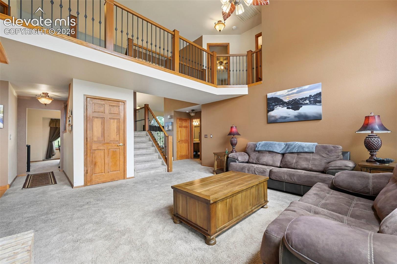 Two-story family room with high ceilings, arched transom windows, and an upper-level railing