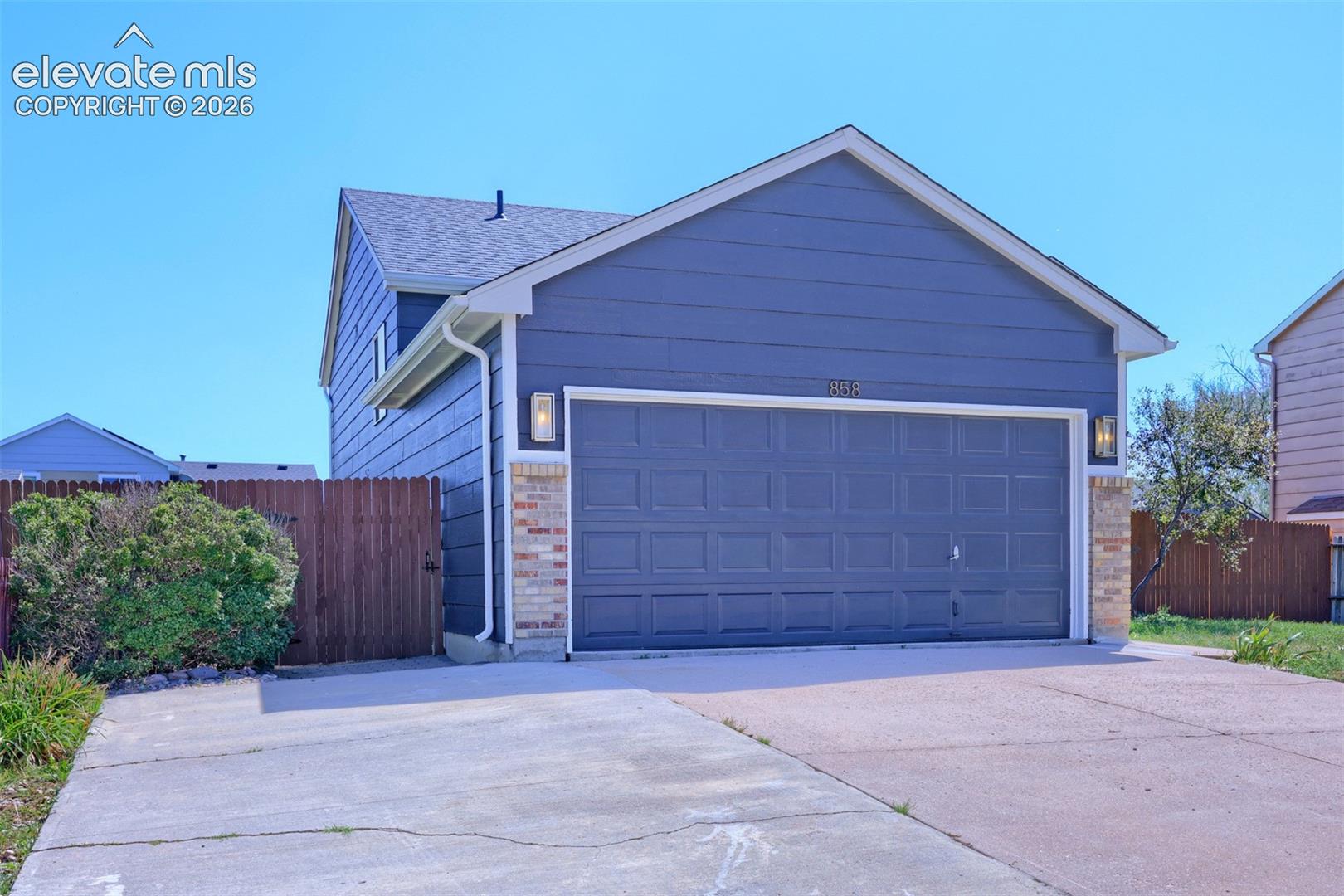 Two-story exterior featuring blue siding and brick accents