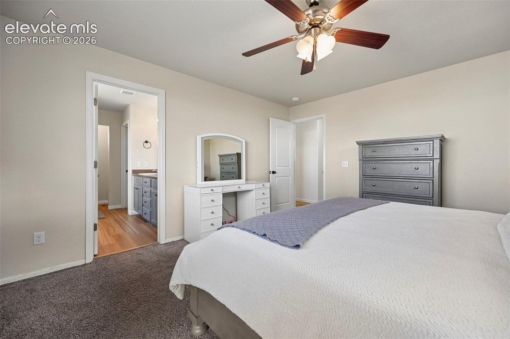 Room featuring neutral wall paint, carpeted flooring, and a ceiling fan with integrated lighting