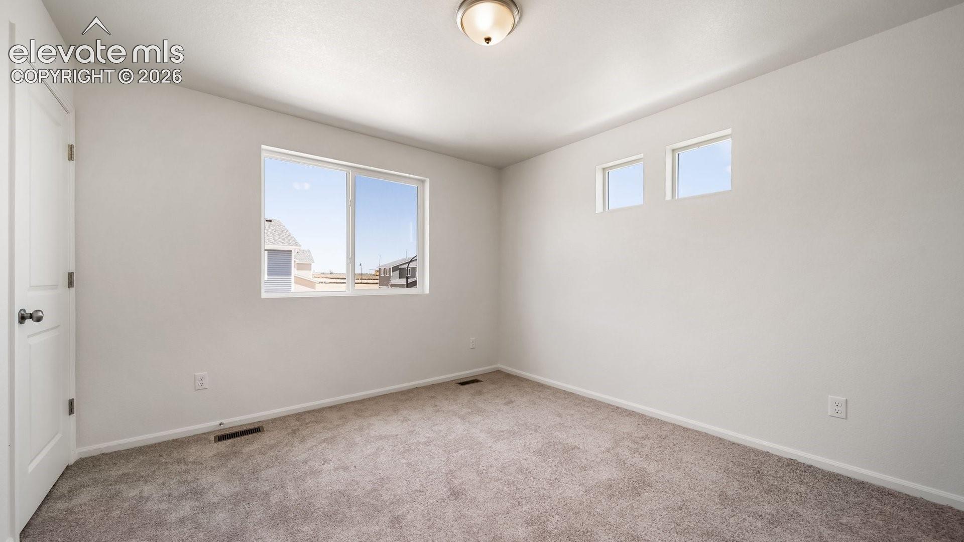 Neutral toned walls and carpeting, white trim, recessed lighting, and multiple windows
*photos of a model home*
