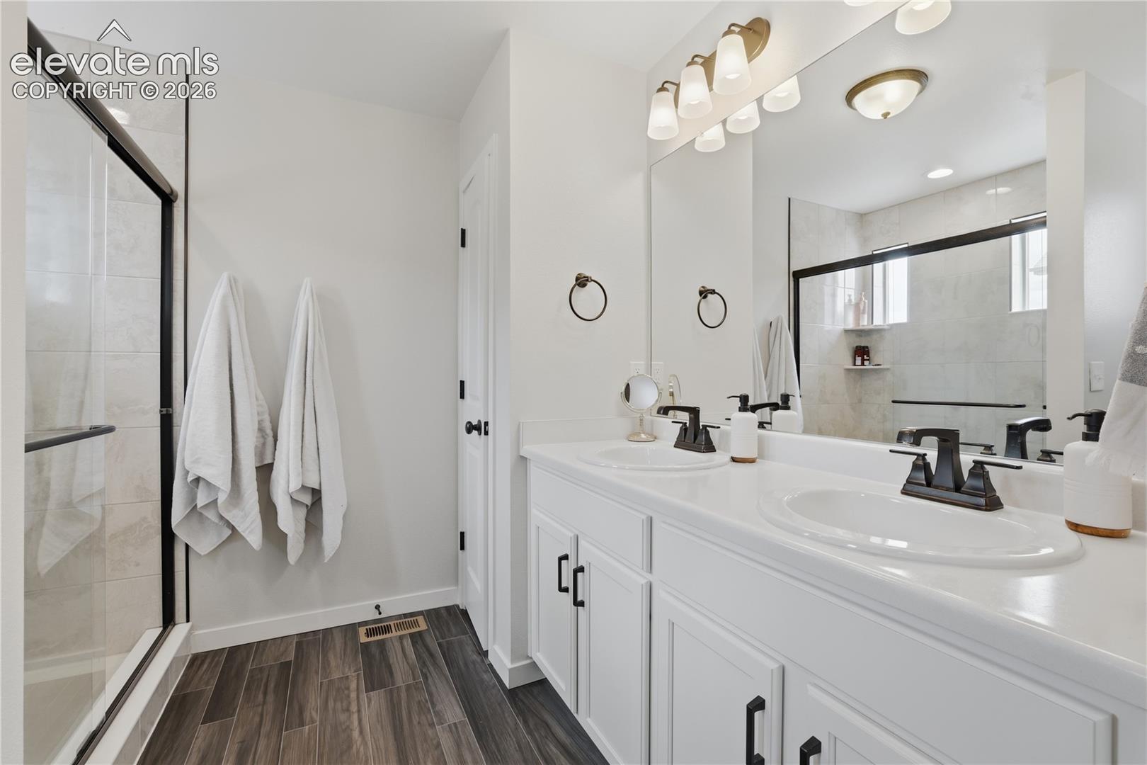 Dual vanity with white cabinetry and solid surface countertops