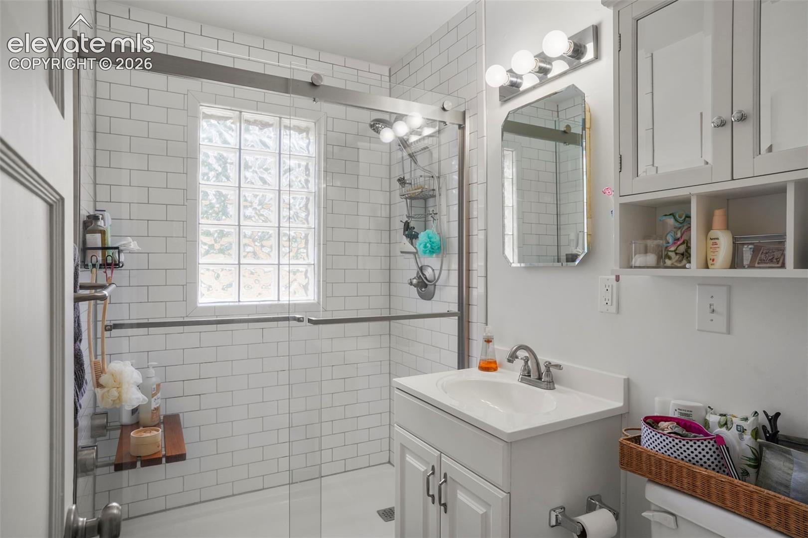 Renovated bathroom with walk in shower and glass shower doors