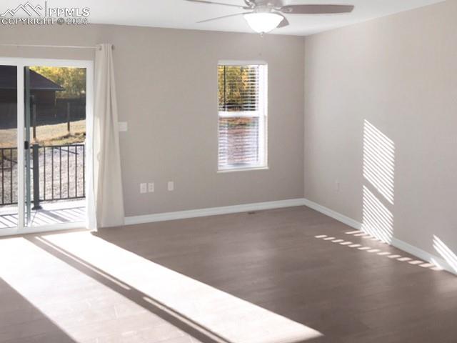 Living room with plenty of natural light, vinyl plank flooring, and a ceiling fan