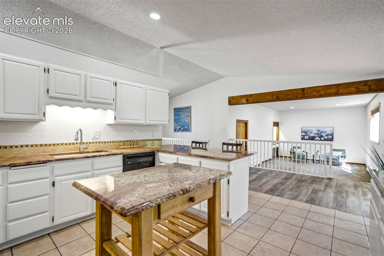 Kitchen featuring white cabinetry, a built-in dishwasher, and a stainless steel sink