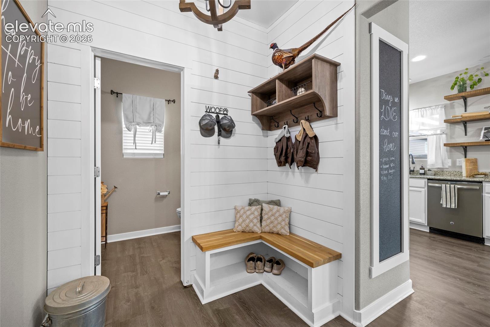Entryway featuring horizontal shiplap wall paneling, built-in corner bench with wood-finish seating, wall-mounted storage shelving with coat hooks, and recessed lighting