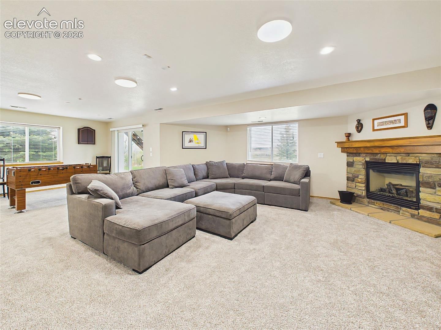 Warm and welcoming entertainment space centered around a beautiful stone fireplace and spacious seating area.