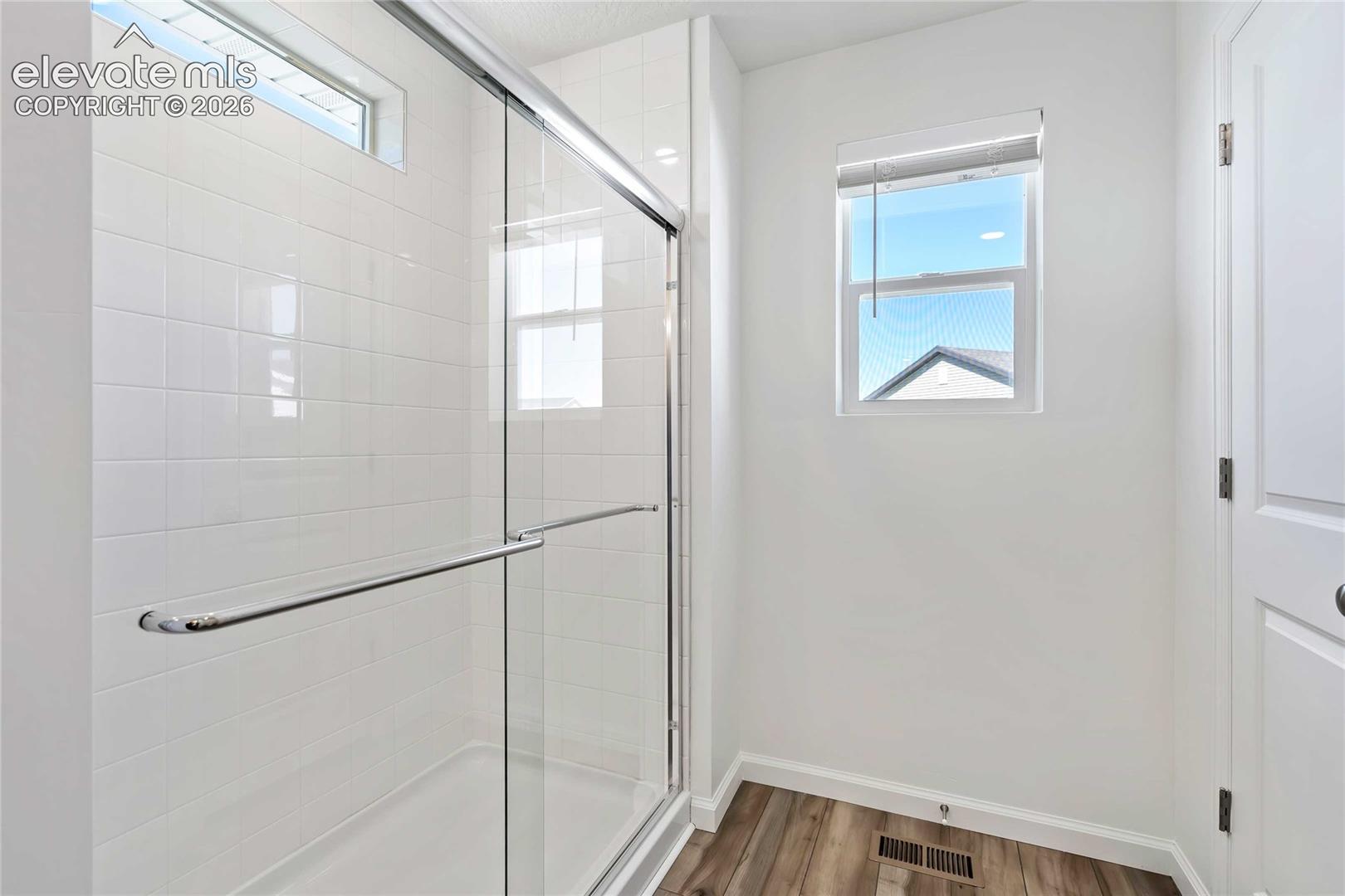 Shower with clear glass enclosure, white subway tile surround, and chrome hardware
*photos of a model home*