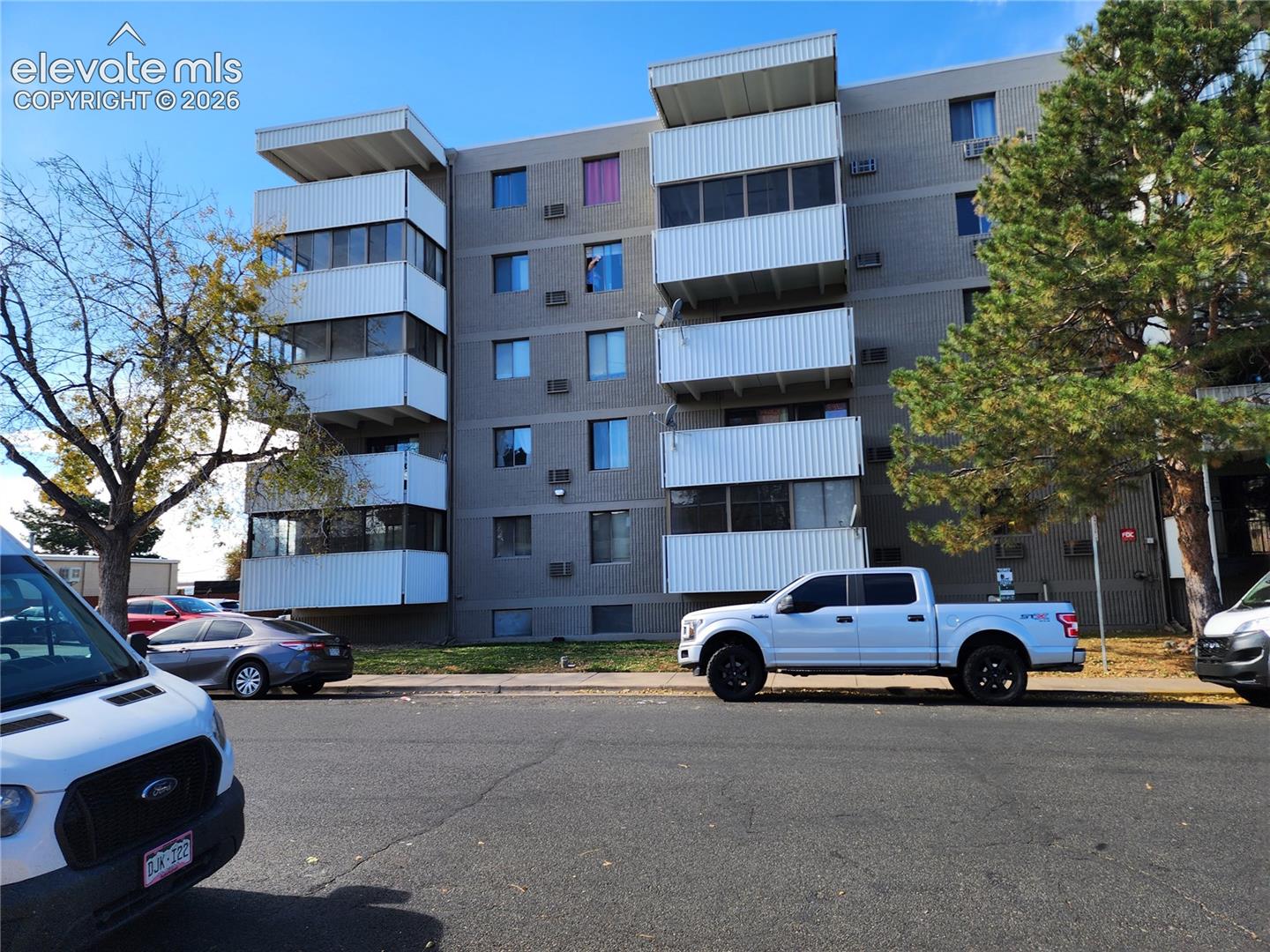 Multi-story residential building exterior featuring masonry facade and private enclosed balconies