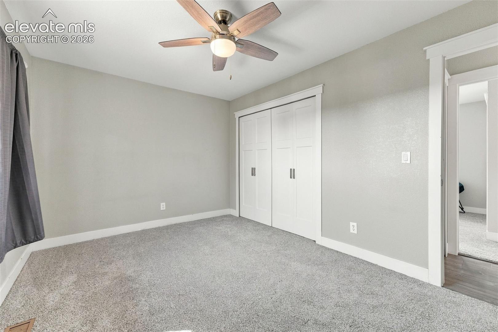 wood-finish ceiling fan, and carpeted flooring