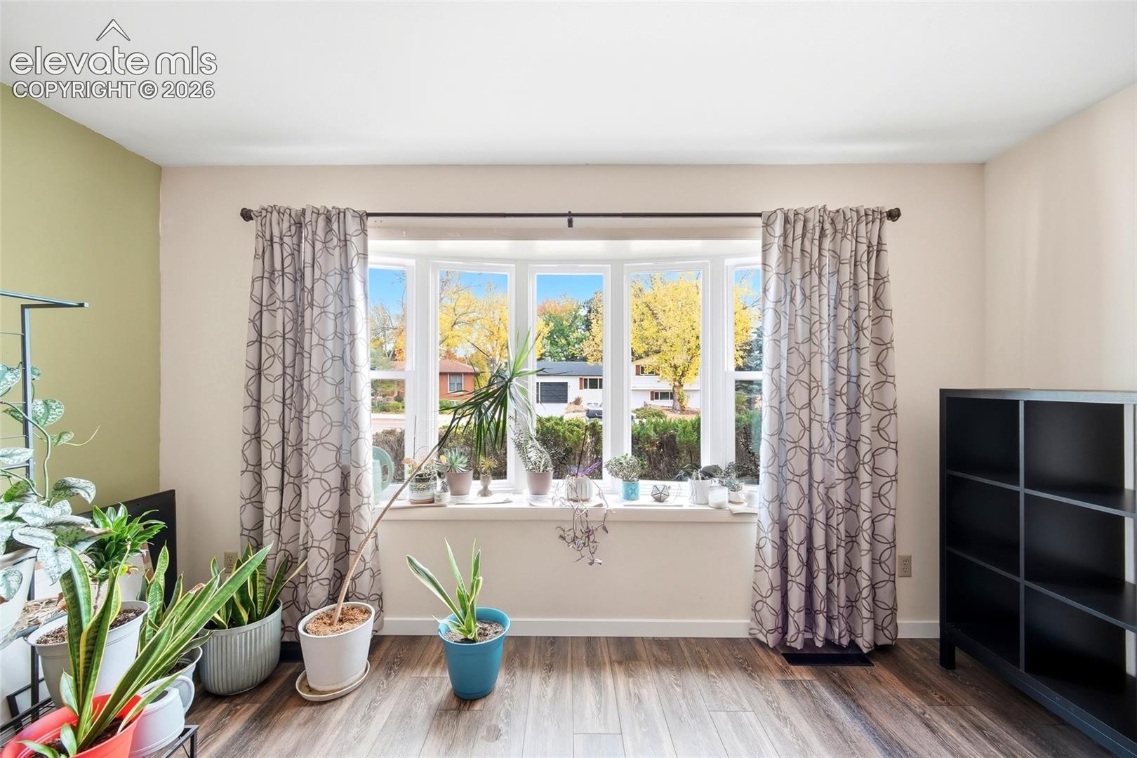 Multi-pane bay window with a deep sill and wood-finish flooring
