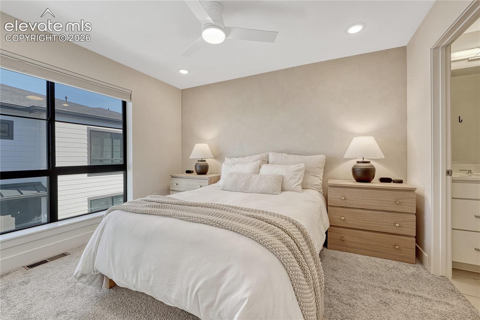 Neutral interior featuring high-performance windows, recessed lighting, and a modern ceiling fan