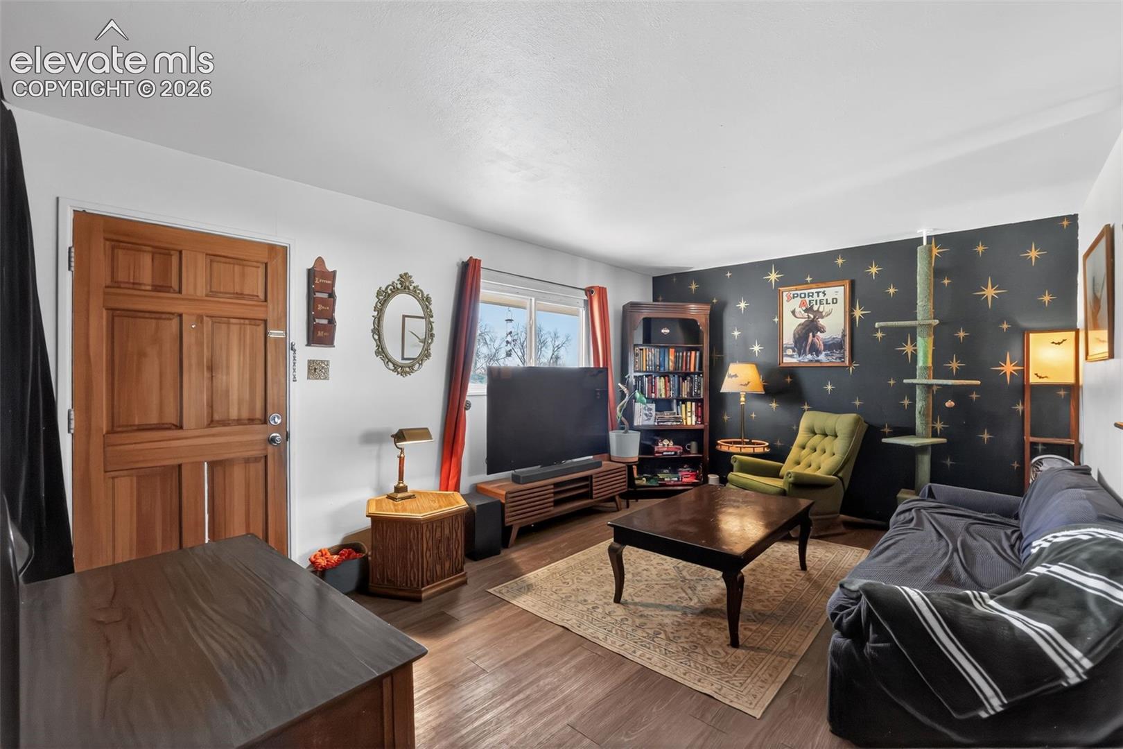 Wood-finish flooring throughout, solid wood entry door, and a built-in shelving unit