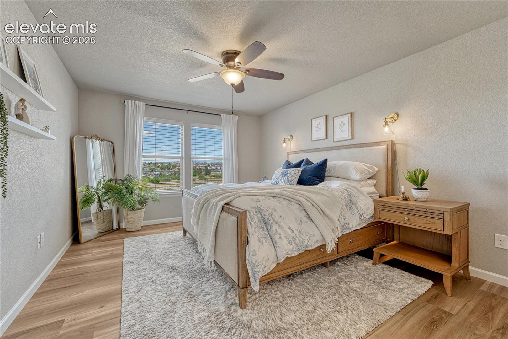 Wake up to natural light and peaceful views in this spacious primary bedroom designed with comfort and relaxation in mind.