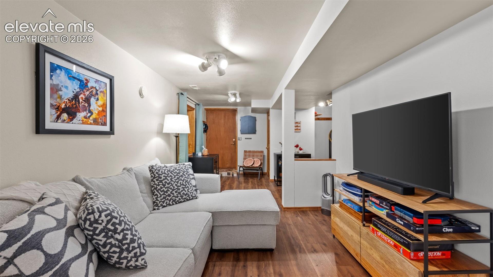 Interior space featuring wood-finish flooring, neutral wall tones, and overhead multi-directional track lighting