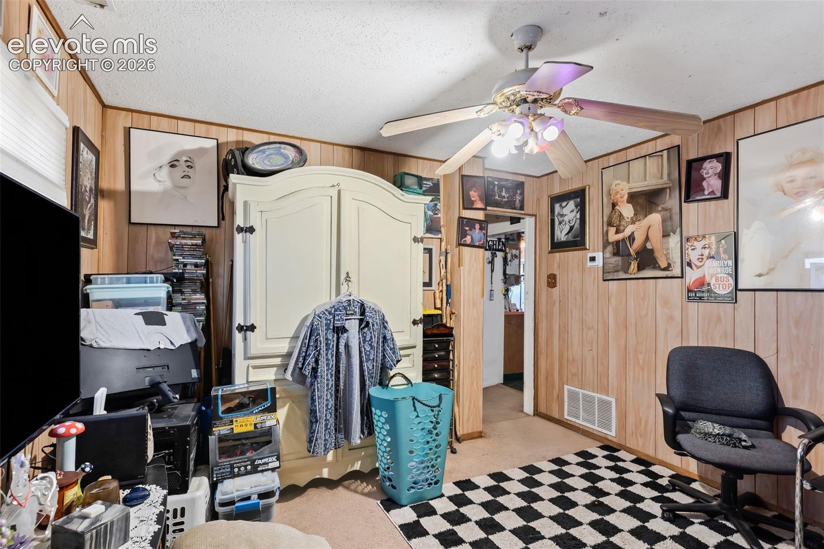 Wall paneling, ceiling fan with integrated lighting, and carpeted flooring