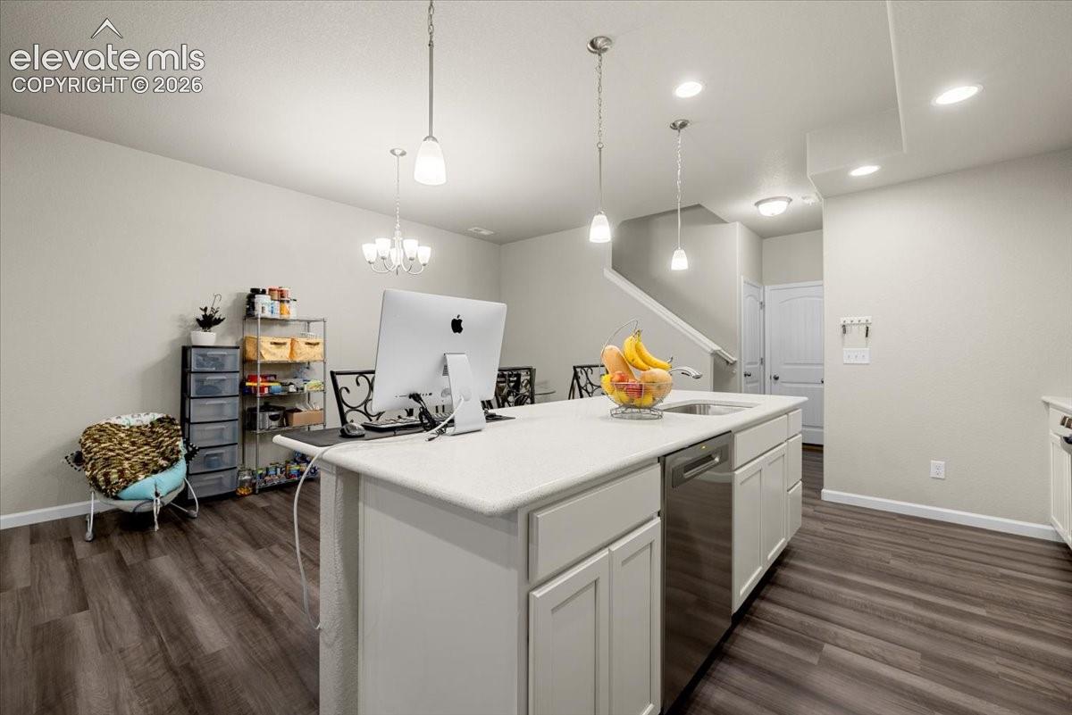 Kitchen island with an undermount sink, a stainless steel dishwasher, and a light-toned countertop