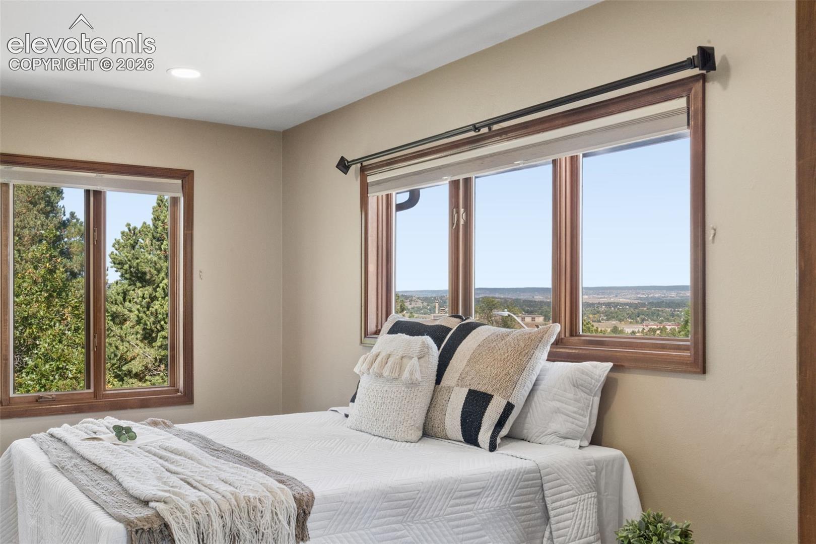 Recessed ceiling lighting, wood-framed windows, and neutral wall tones