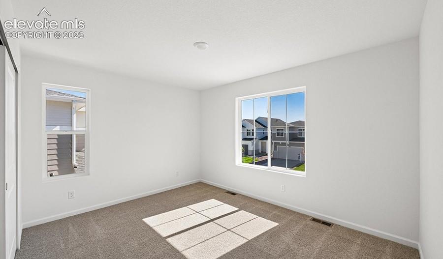 Neutral interior featuring wall-to-wall carpeting and dual windows providing natural lighting