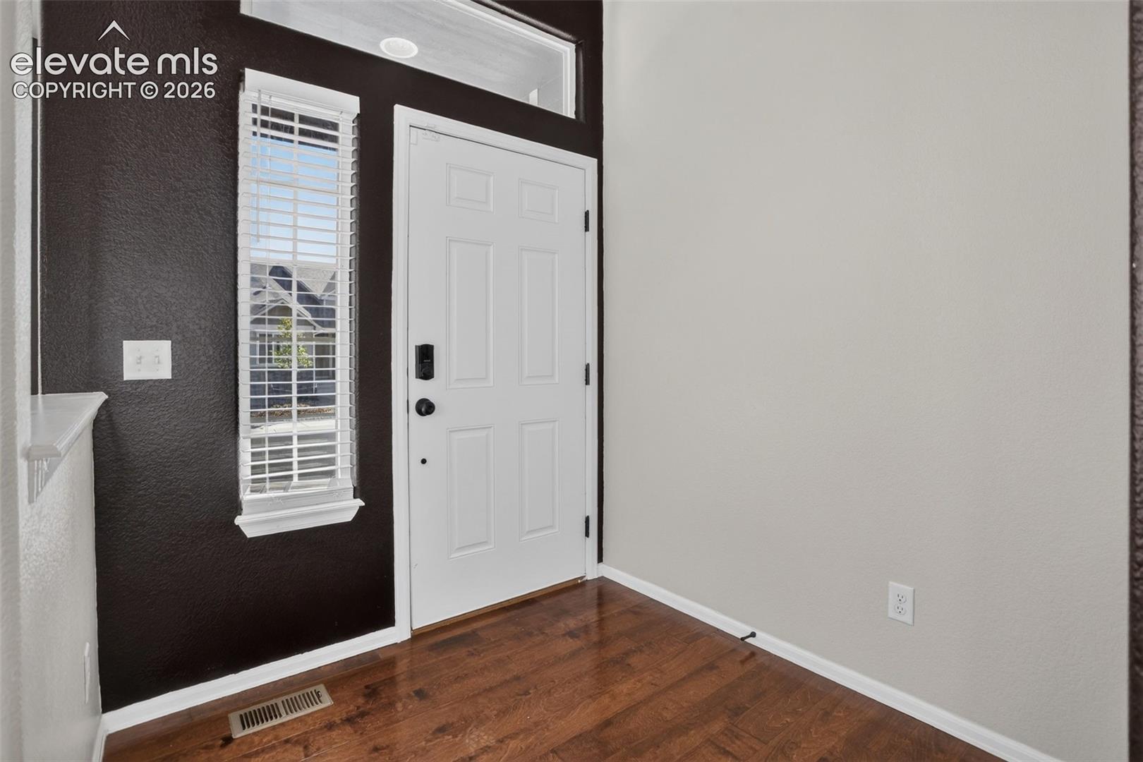 Entryway featuring a white paneled door, sidelight with blinds, wood-finish flooring, and recessed lighting