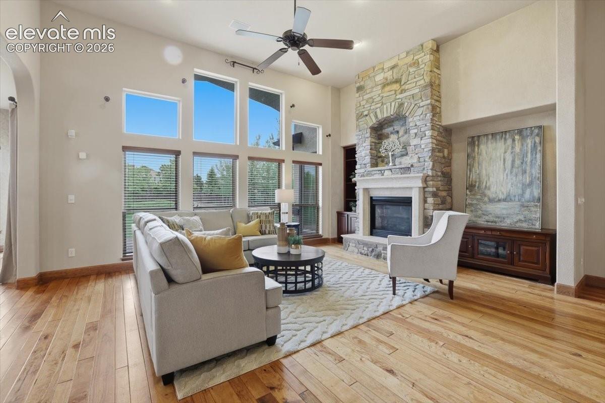 Spacious Great Room with vaulted ceiling, custom built-ins, Gas fireplace with Stone Surround, Speakers, and Wood Flooring!