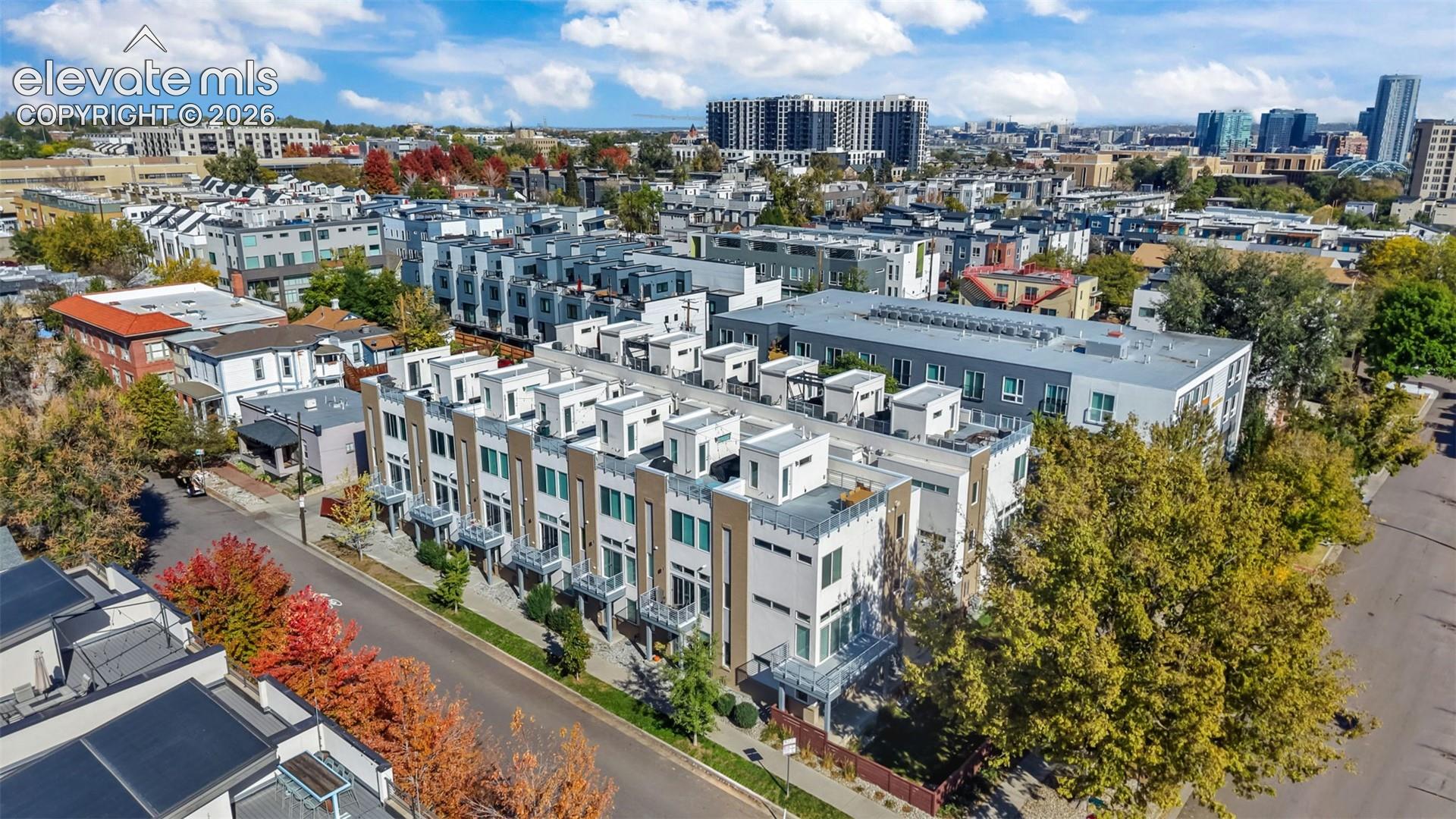 Aerial perspective of multi-level townhomes featuring clean architectural lines, flat roofing, metal railings, and private terraces