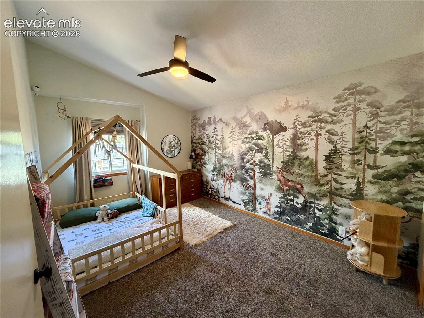 Upstairs bedroom room featuring a vaulted ceiling with a ceiling fan