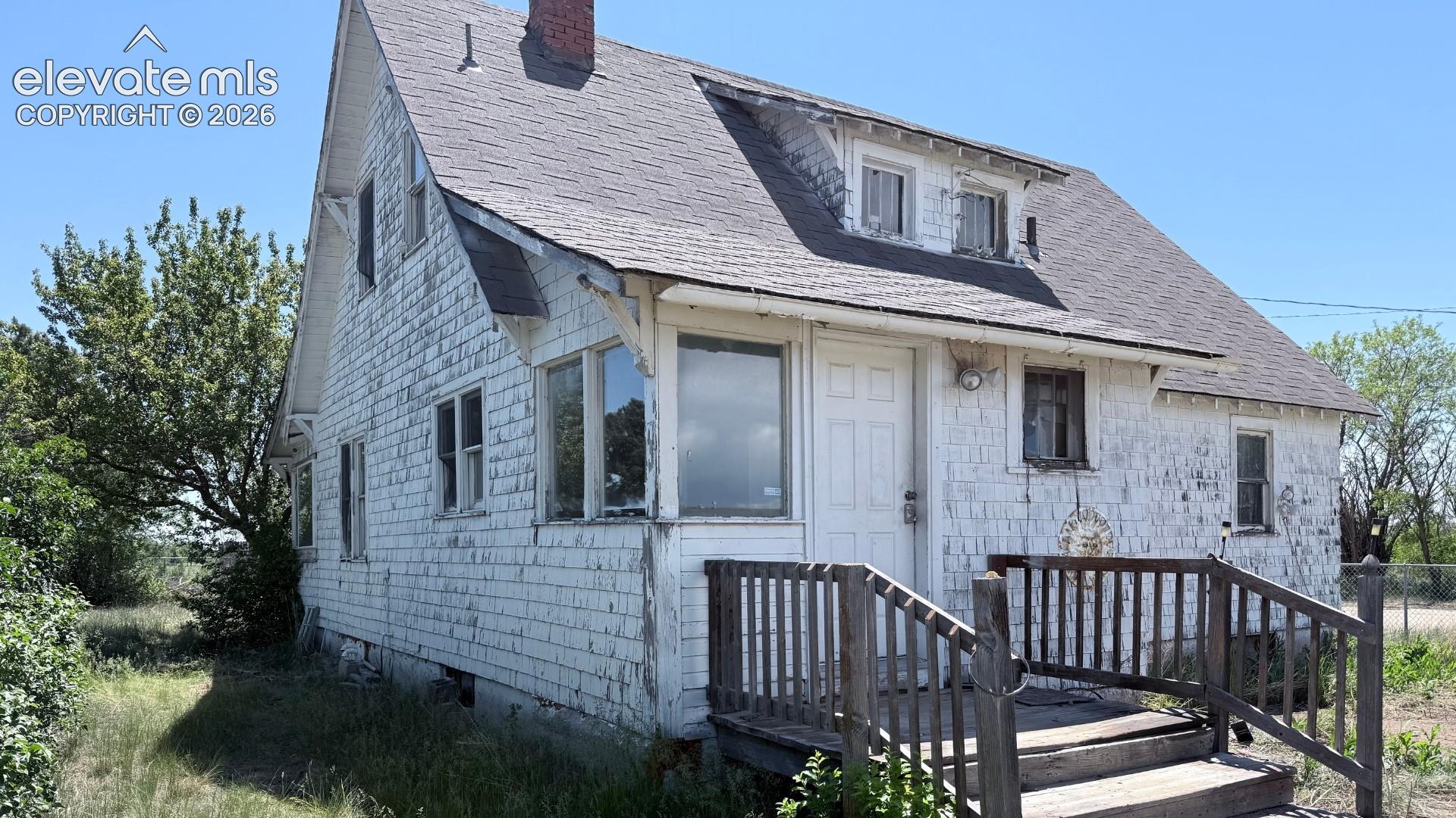 White shingle-sided home with an asphalt shingle roof